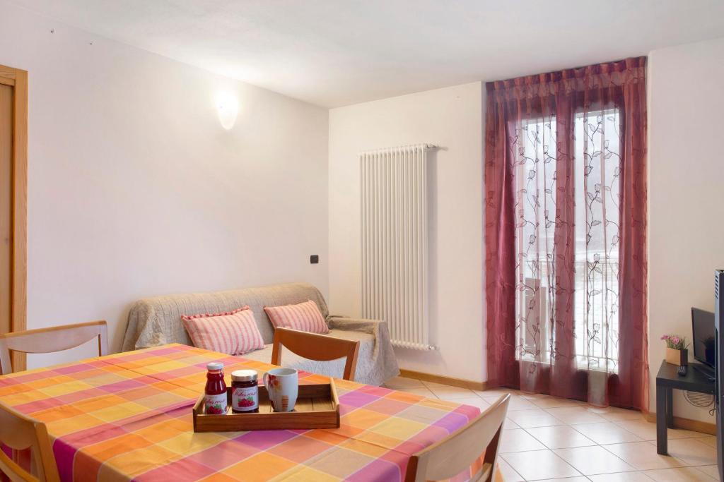 een woonkamer met een tafel en een raam bij Casa Vacanze Gilda in Chiesa in Valmalenco