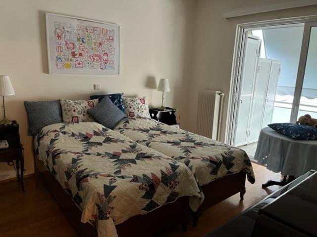um quarto com uma cama com uma colcha em Spacious and sunny appartment in Cholargos em Atenas