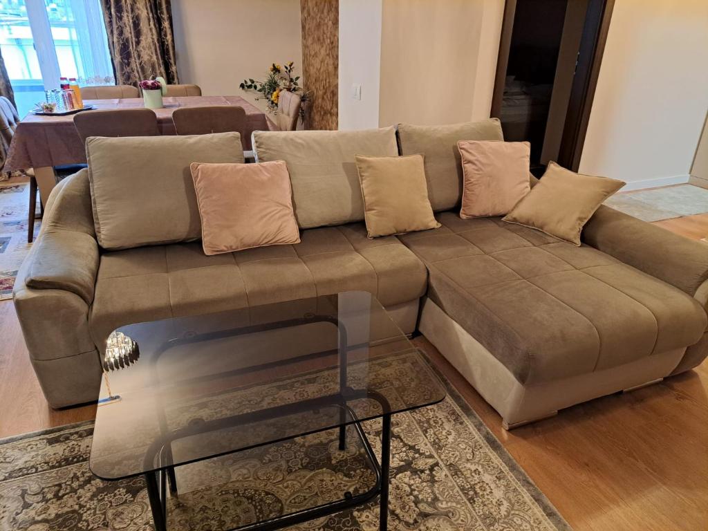 a brown couch in a living room with a glass table at Monica City Apartament in Timişoara