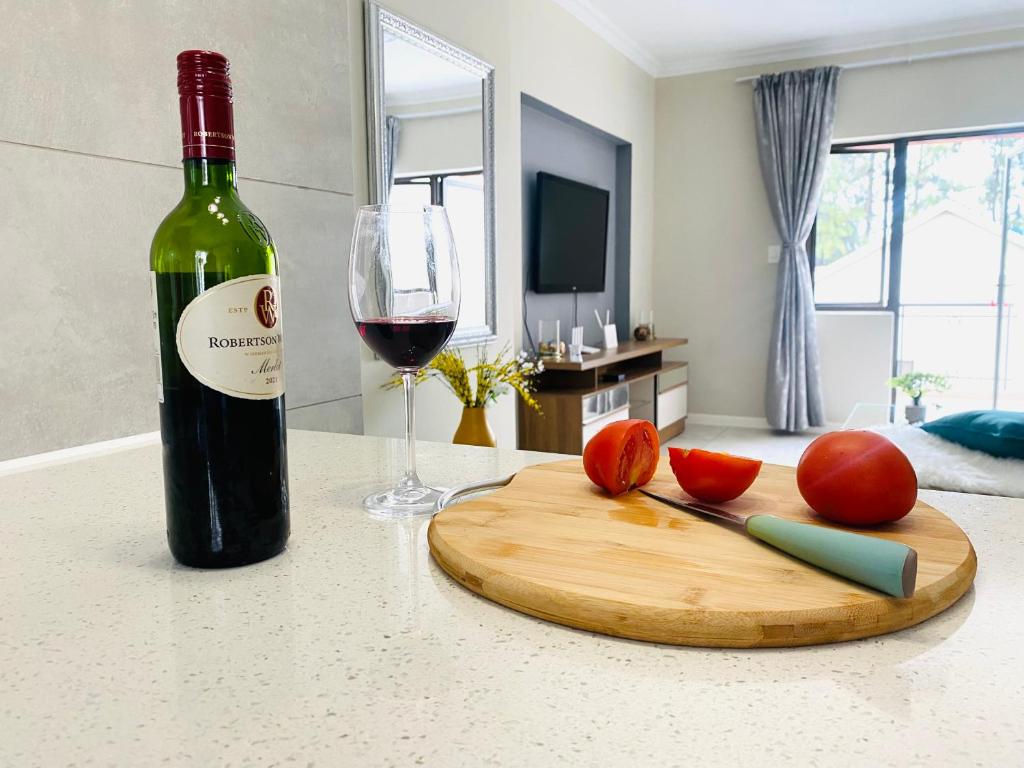 Sandton的住宿－At Home，一瓶葡萄酒、一把刀和一杯葡萄酒