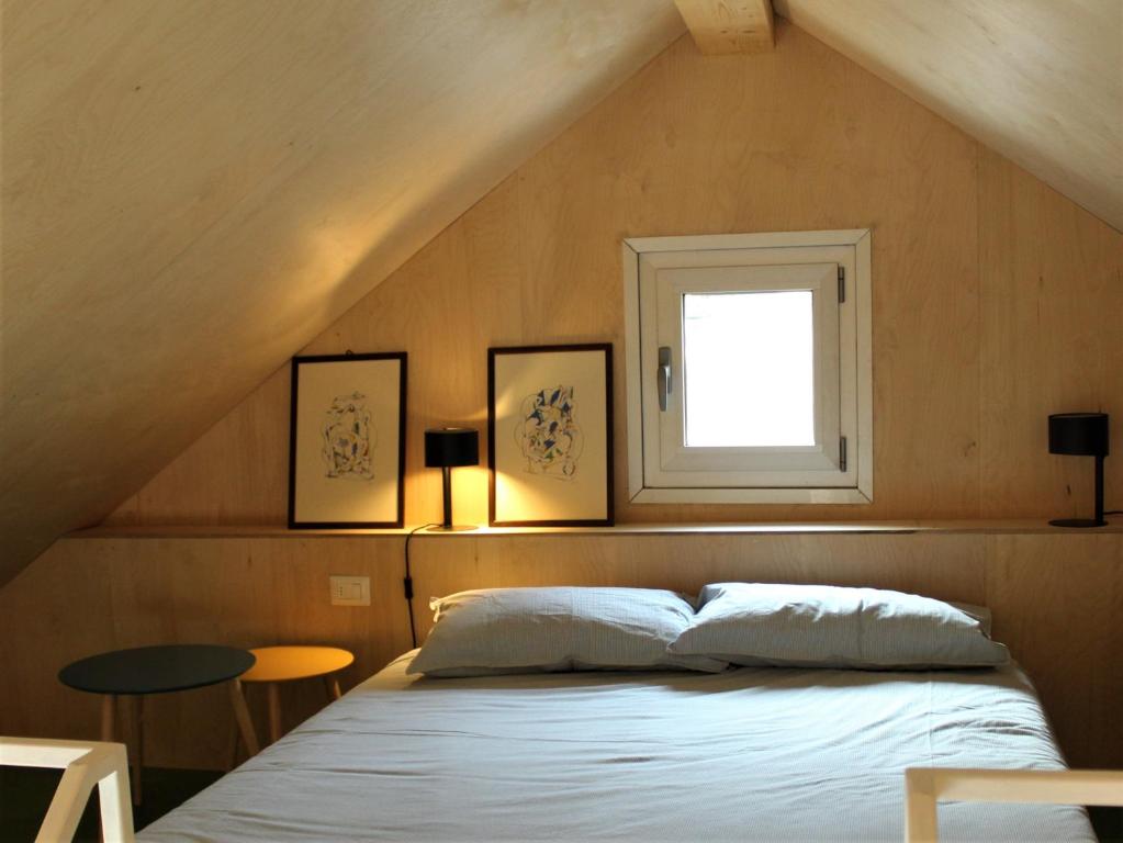 a bedroom with a bed with a window and a table at Maison 4 petite Casa design nel parco naturale in Crodo