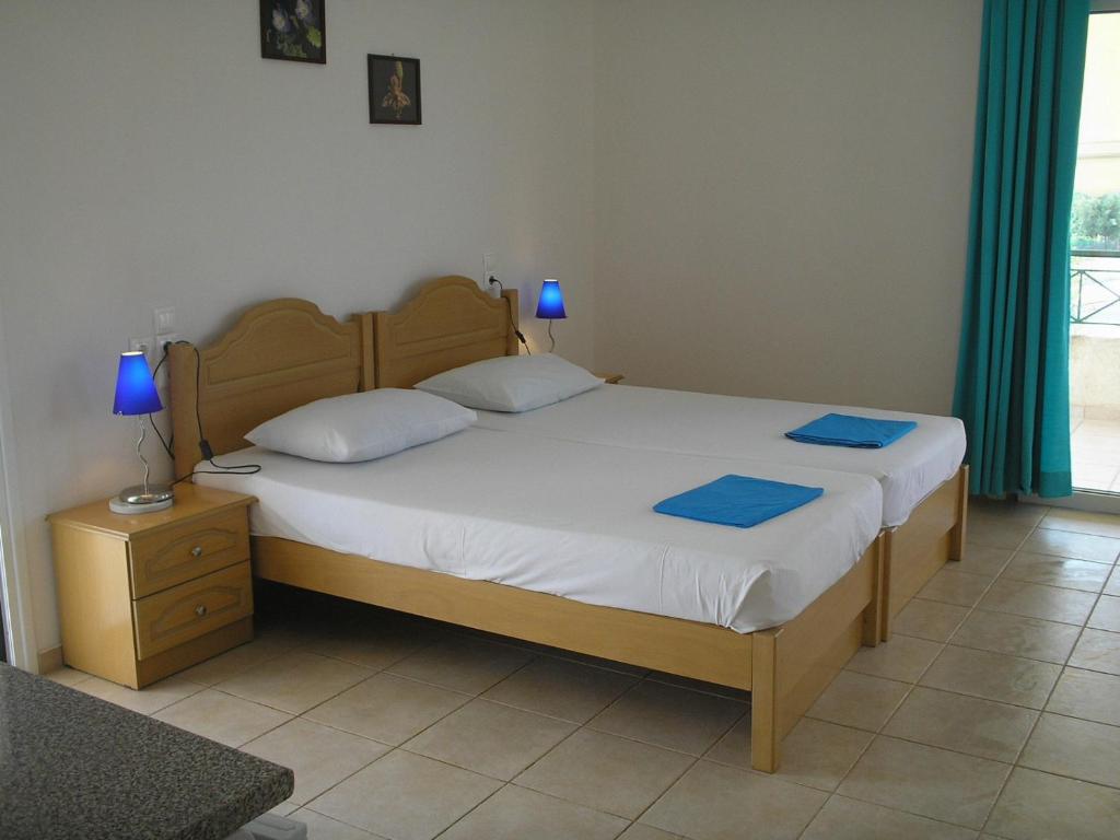 a bedroom with a large bed with blue lamps on it at Agnanti Studios in Amaliápoli