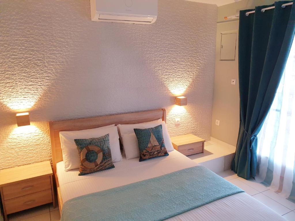 1 dormitorio con cama con almohadas y ventana en Deluxe Apartment near the Airport Adults Only, en Porto Rafti