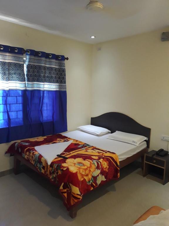 een slaapkamer met een bed en een raam bij Blue Moon Residency in Mysore