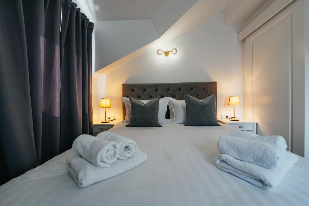 a bedroom with a white bed with towels on it at BOUTIQUE APARTMENTS IMOTSKI, Imotski - Makarska in Imotski