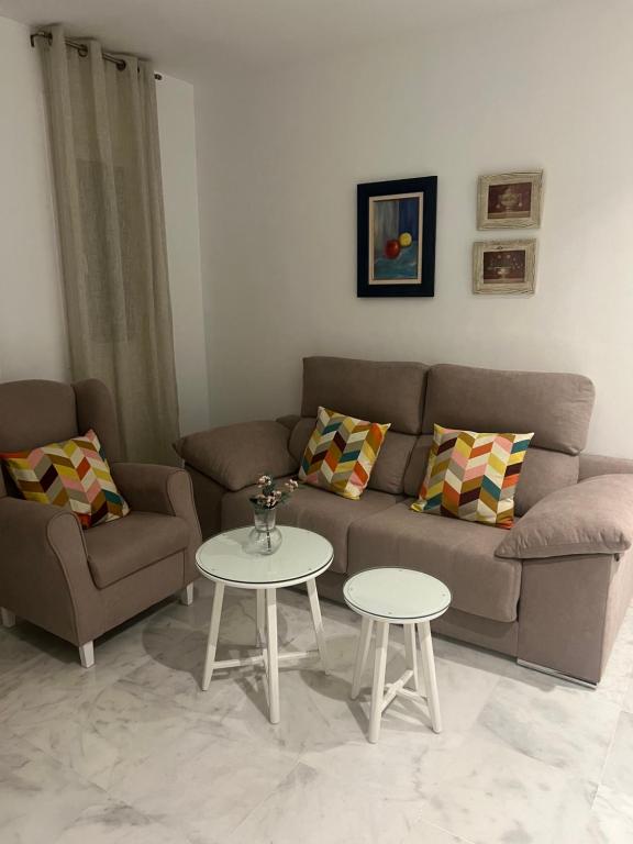 ein Wohnzimmer mit einem Sofa und einem Tisch in der Unterkunft Casa vacacional equipada in Lebrija