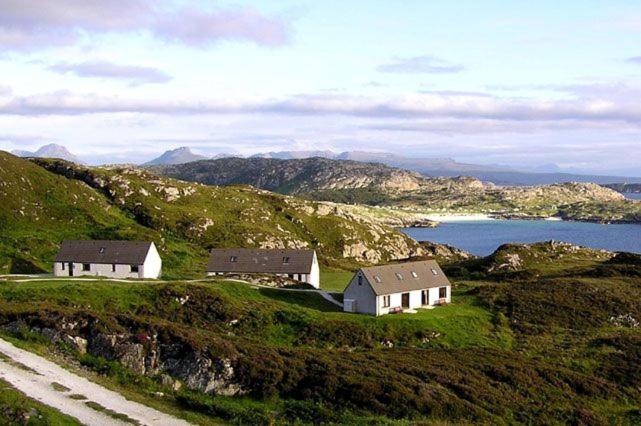- deux maisons sur une colline à côté d'une nappe d'eau dans l'établissement Fern Cottage, à Lairg