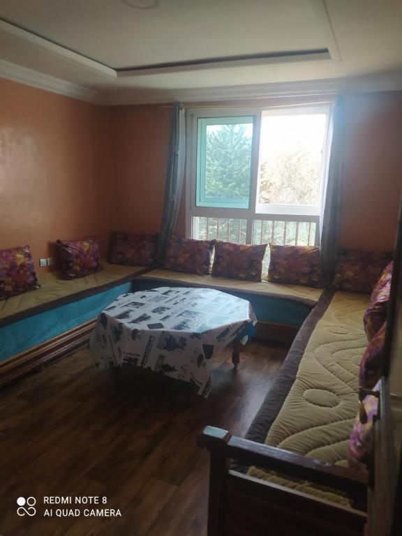 N7 Residence Bien Etre pour famille في إفران: غرفة بها أريكة وسرير ونافذة