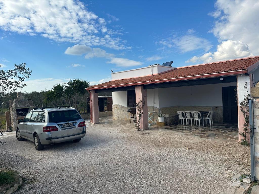 un coche blanco estacionado frente a una casa en Villetta Forestaforte, en Leuca