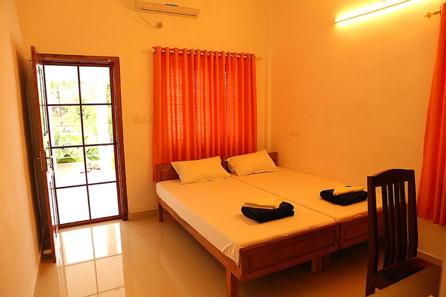 a bedroom with a bed and a window and a window at Aleenas homestay in Cochin