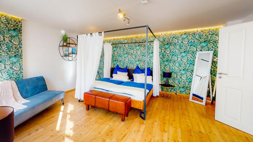 - une chambre avec un lit à baldaquin et un canapé dans l'établissement Alte Schmiede, à Passau