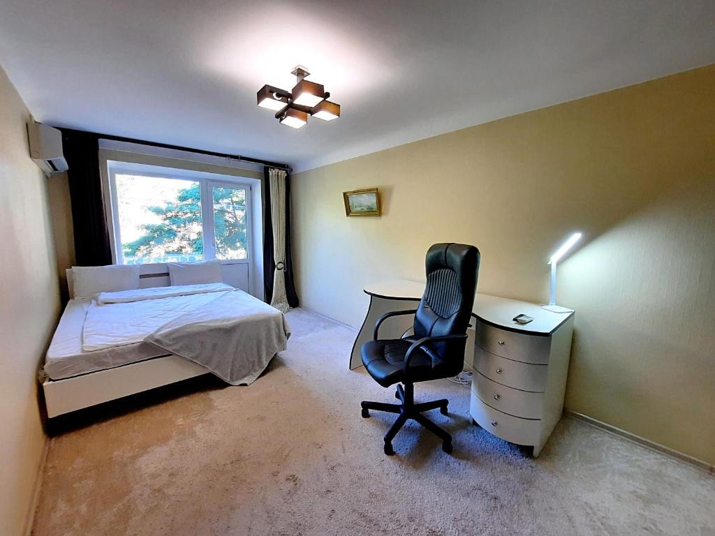 1 dormitorio con cama, escritorio y silla en Один каштан Мережа Alex Apartments Безконтактне заселення 24-7, en Poltava
