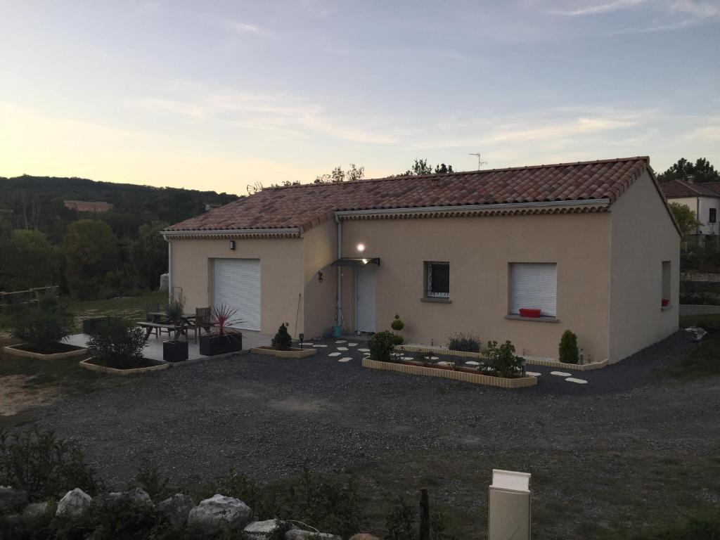 uma casa com uma grande entrada de garagem em frente em Brugière em Vogüé