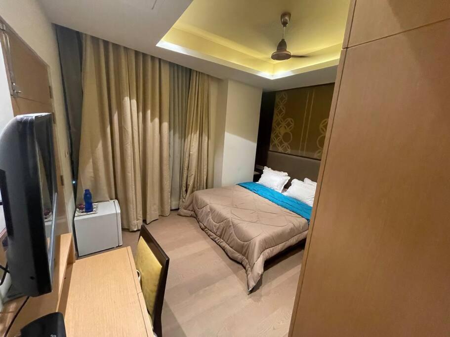 una piccola camera con letto e televisore di Luxurious 5 Star Studio Apartment a Calcutta