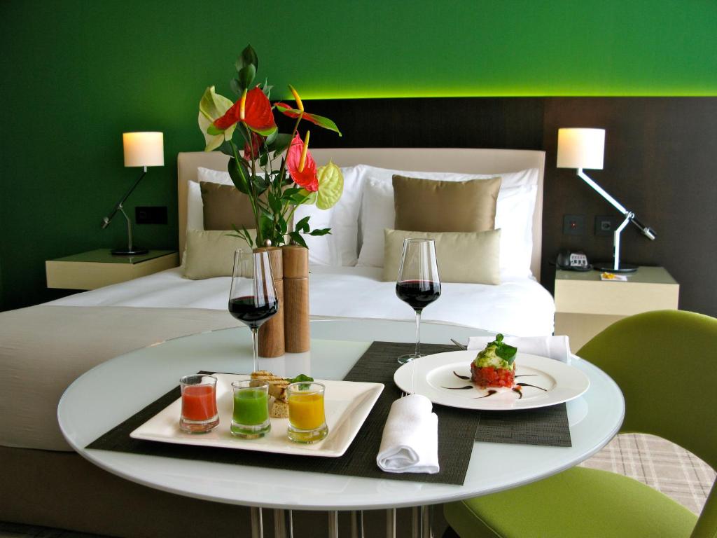 einen Tisch mit zwei Teller Essen und Gläsern Wein in der Unterkunft Crowne Plaza Geneva, an IHG Hotel in Genf