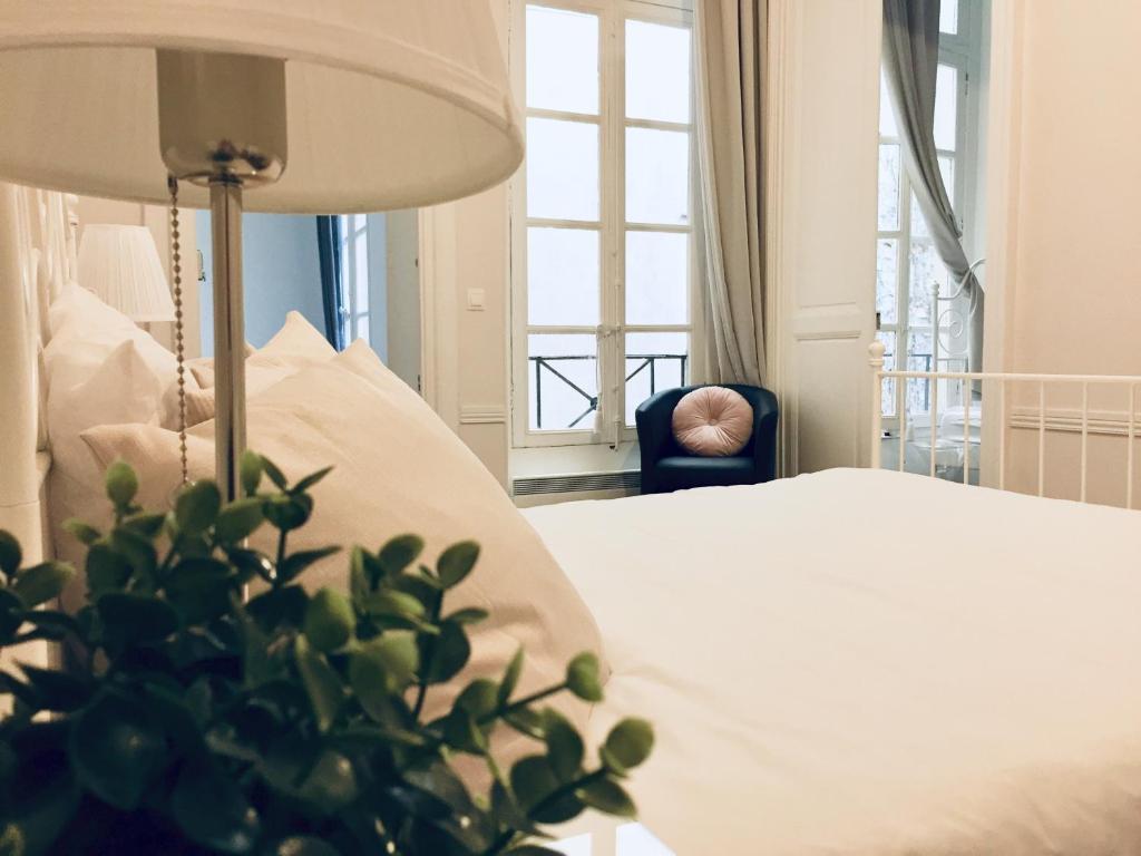 パリにあるAppartement Maraisのベッドルーム1室(ベッド1台、椅子、窓付)
