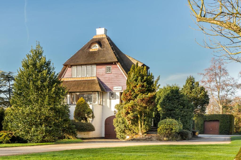 Cette grande maison blanche est dotée d'un toit de chaume. dans l'établissement De Kievit, à Vogelenzang