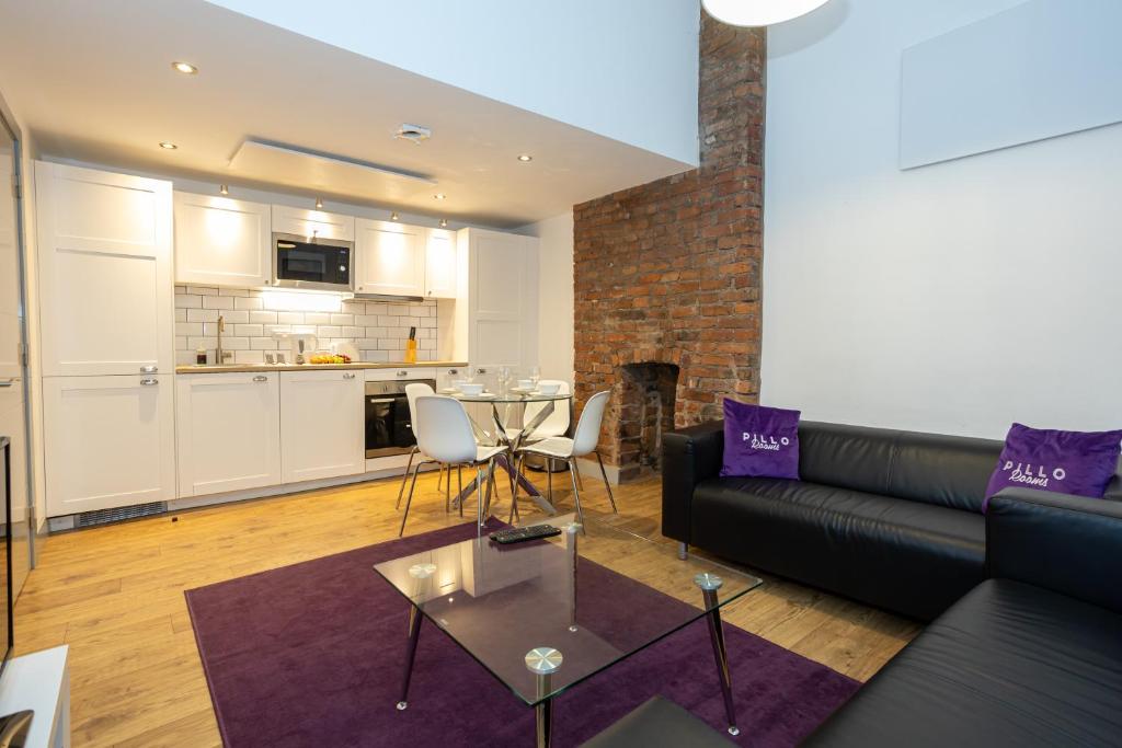 ein Wohnzimmer mit einem Sofa und einem Tisch in der Unterkunft Pillo Rooms Serviced Apartments - Salford in Manchester