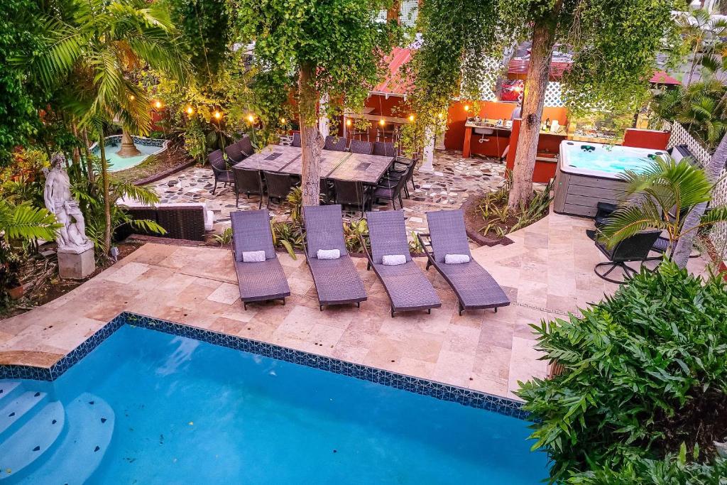 an outdoor patio with chairs and a table and a pool at Luxurious San Juan Villa with Pool - Walk to Beach! in San Juan