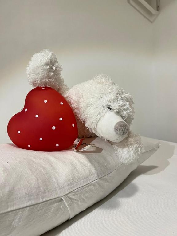 a stuffed teddy bear with a red hat on a pillow at La Tanière de l'Ours Blanc Aubagne-Cassis-Aix en Provence in Aubagne