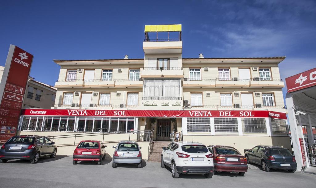 a group of cars parked in front of a building at Hostal Venta Del Sol in Baza