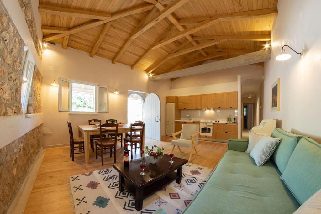 - un salon avec un canapé vert et une table dans l'établissement AVLI - Tranquil stonehouse in Lefkada, à Alexandros