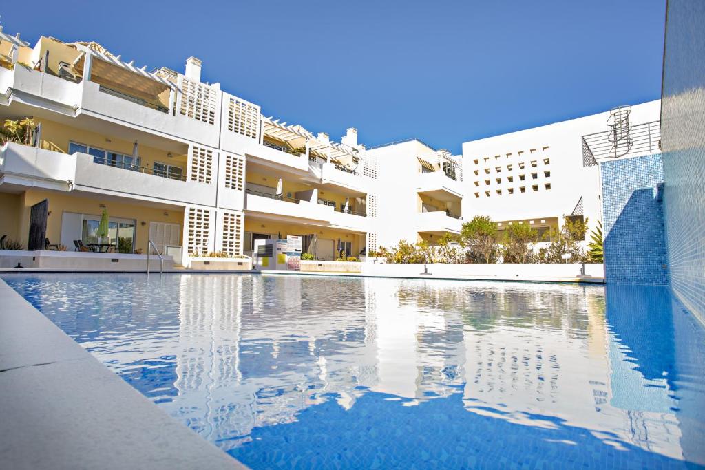 a swimming pool in front of a building at Welcome Cabanas Beach in Cabanas de Tavira