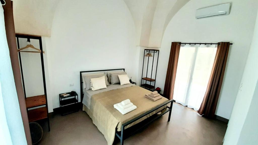 1 dormitorio con cama y ventana grande en Casina Pompiliano, en Nardò