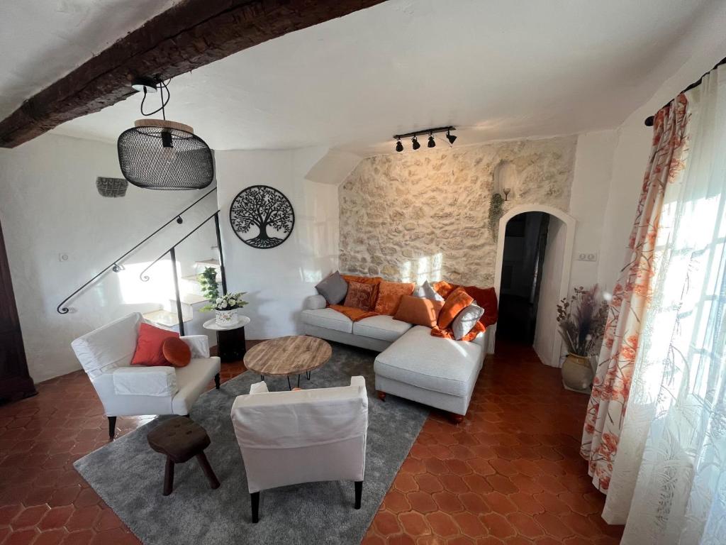 a living room with white furniture and a stone wall at Villa Harmonie - unique provençal charm in Antibes