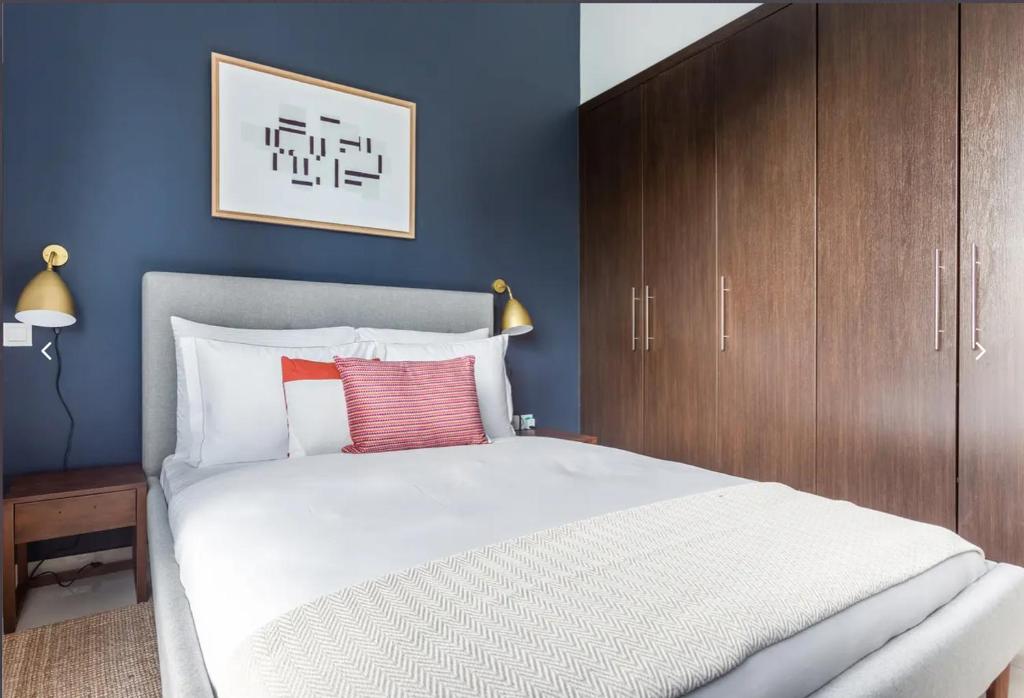 una camera con un grande letto bianco e armadi in legno di شقق فندقية a Dubai
