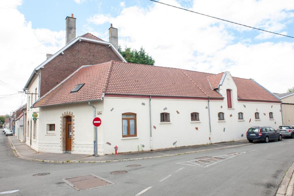 a white building with a brown roof on a street at Les Gîtes d&#39;Angres - gîte n°1 in Angres