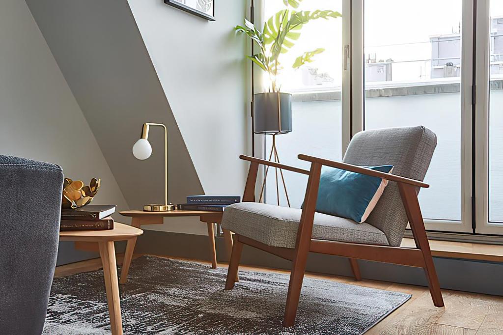 a living room with a chair and a table at Holborn by Viridian Apartments in London