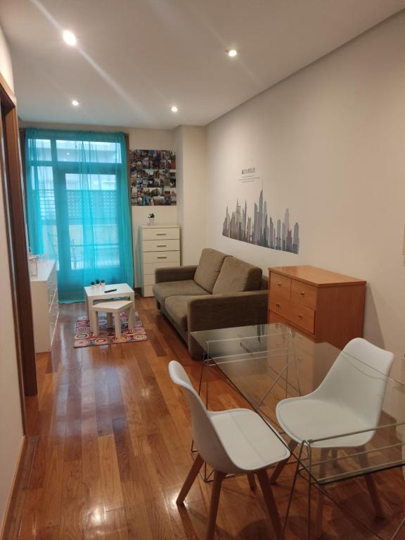 - un salon avec un canapé, une table et des chaises dans l'établissement Pleno centro, Terraza, Principe, 5 min casco vello y estación AVE, à Vigo