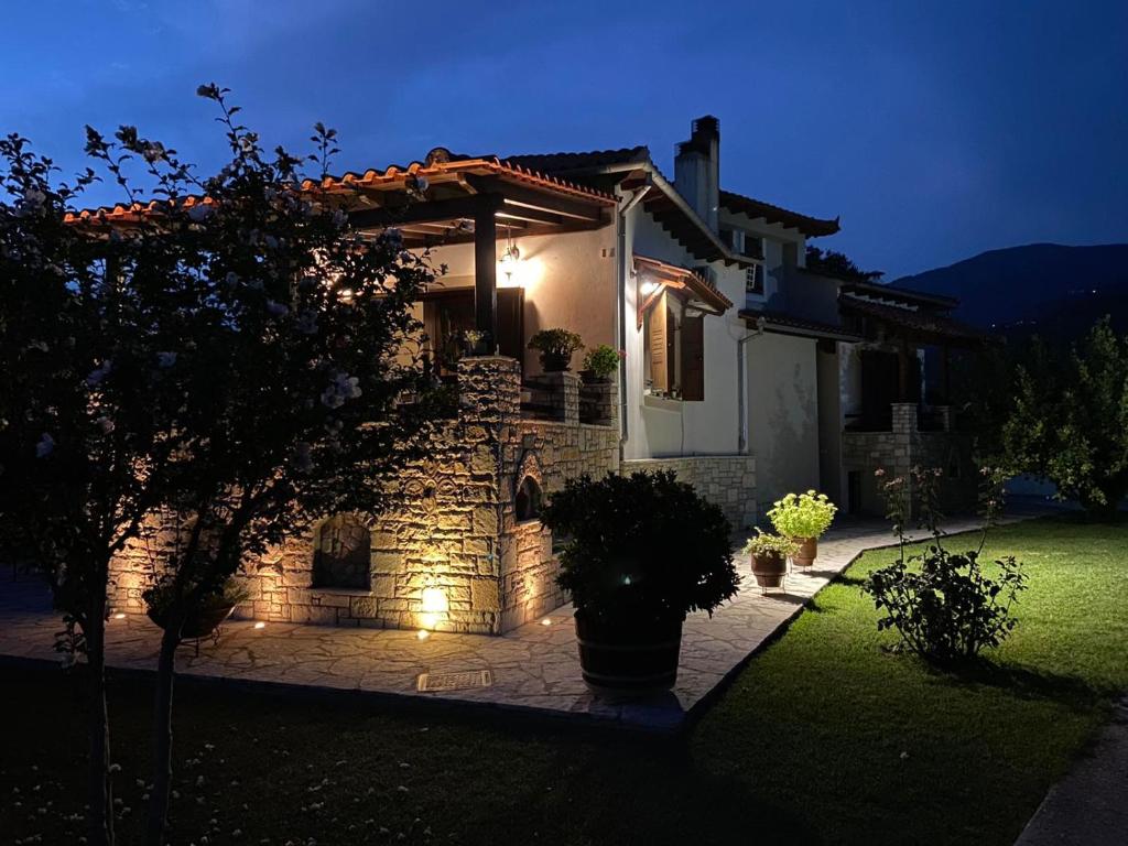 a house with lights in the yard at night at ZENIA Pelion garden house in Platanidia
