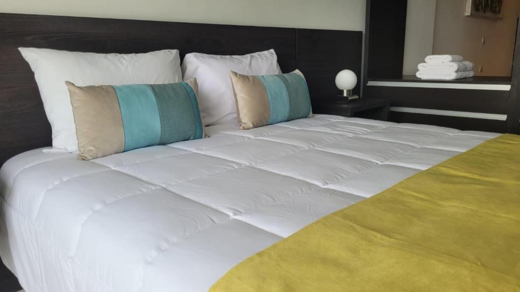 1 cama grande con sábanas y almohadas blancas en Dessau VI en San Luis