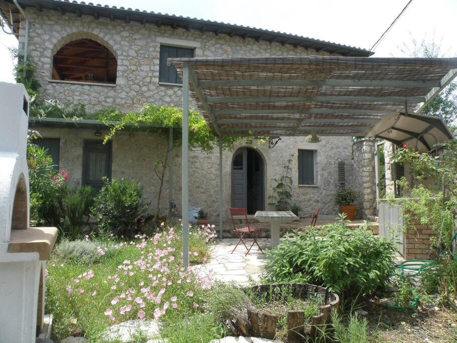 una casa con una pérgola de madera en un jardín en THEO en Alexandros