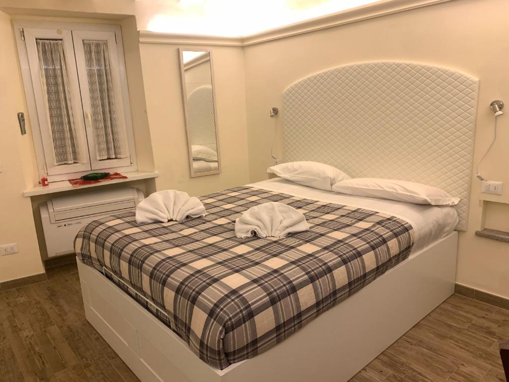 ein Schlafzimmer mit einem Bett mit zwei Hüten darauf in der Unterkunft GB apartments in Florenz