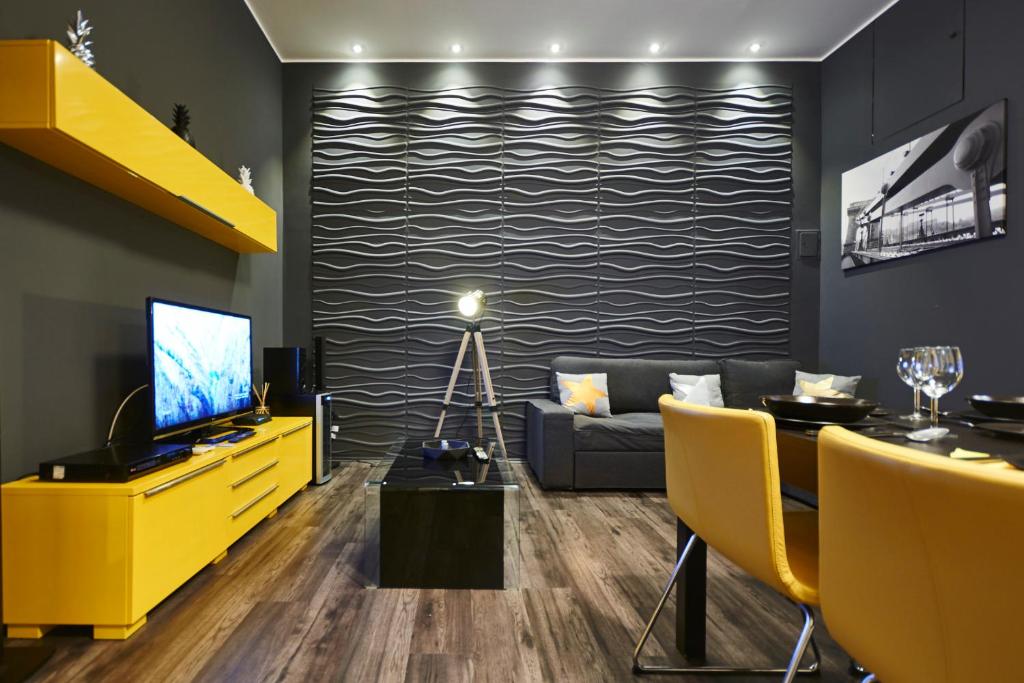 Televízia a/alebo spoločenská miestnosť v ubytovaní Central Location Yellow-Black Apartment