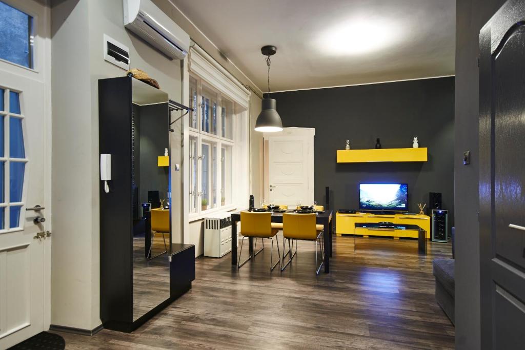 Televízia a/alebo spoločenská miestnosť v ubytovaní Central Location Yellow-Black Apartment