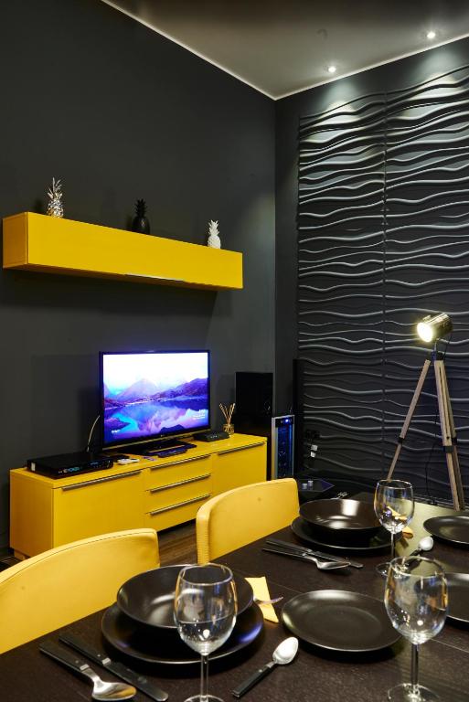 Televízia a/alebo spoločenská miestnosť v ubytovaní Central Location Yellow-Black Apartment