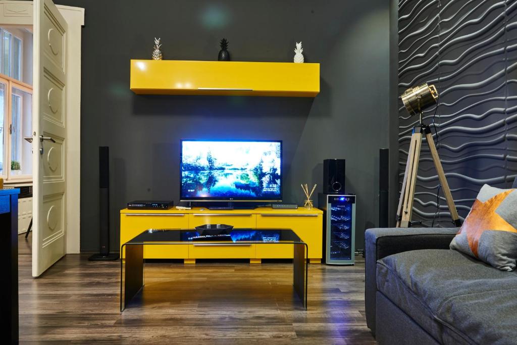 Televízia a/alebo spoločenská miestnosť v ubytovaní Central Location Yellow-Black Apartment
