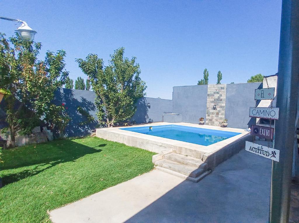 a swimming pool in a yard next to a house at La casa de Beatriz Paz, confort y tranquilidad in San Rafael