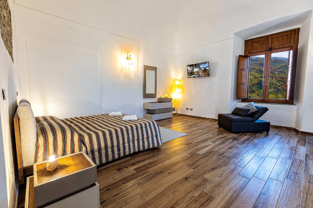 een slaapkamer met een bed en een stoel erin bij La Dimora del Duca Luxury in Giungano