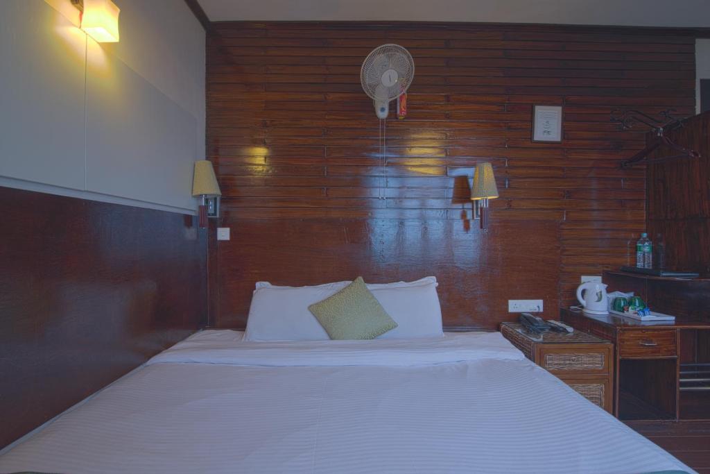 a bedroom with a large bed and a wooden wall at The Nettle and Fern Hotel Gangtok in Gangtok