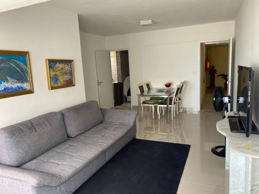 Sala de estar con sofá gris y mesa en apto na quadra do mar, en Recife