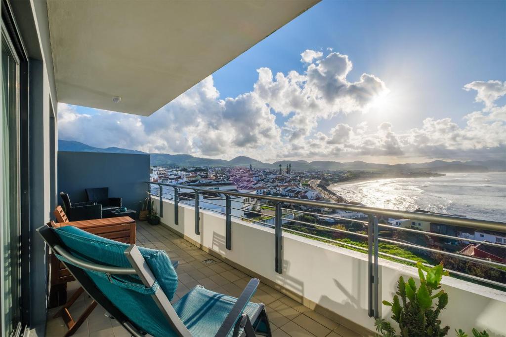 a balcony with a chair and a view of the beach at Mar Grande Apartment in Ribeira Grande