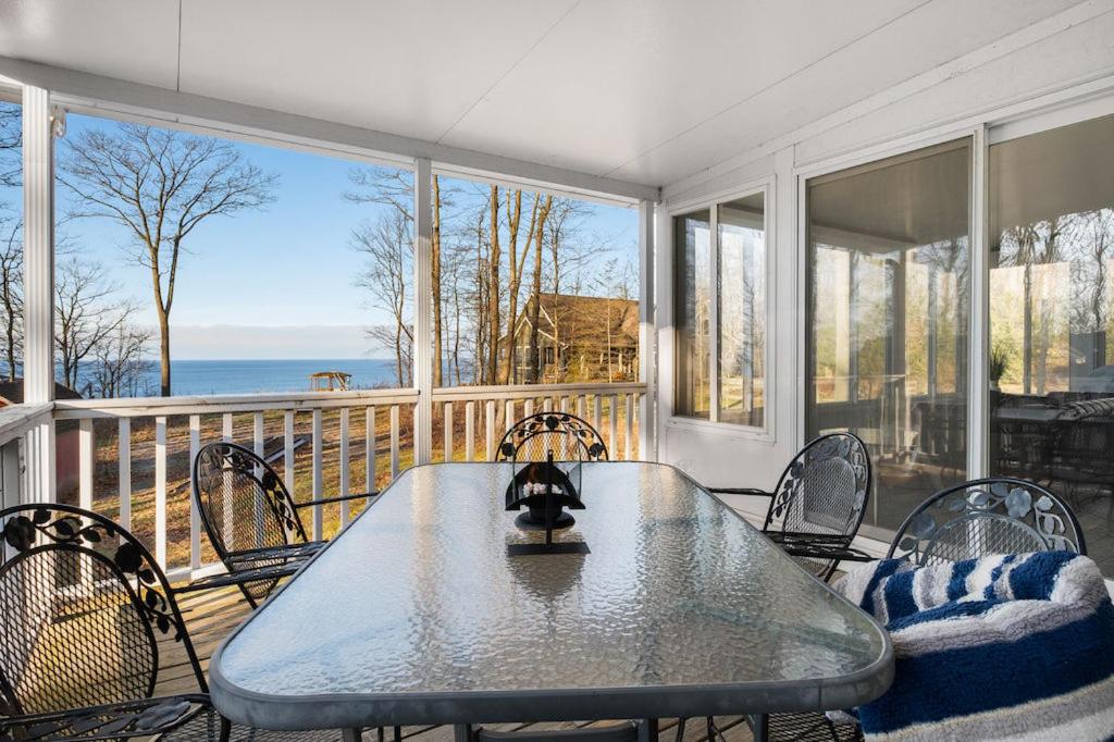 ein Esszimmer mit einem Tisch und Stühlen auf dem Balkon in der Unterkunft Lakefront Getaway by Michigan Waterfront Luxury Properties in Rothbury