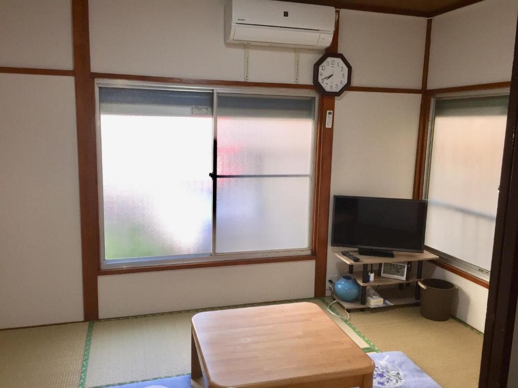 a living room with a tv and two windows at D-pdal Inn 1F - Vacation STAY 14134 in Tokyo