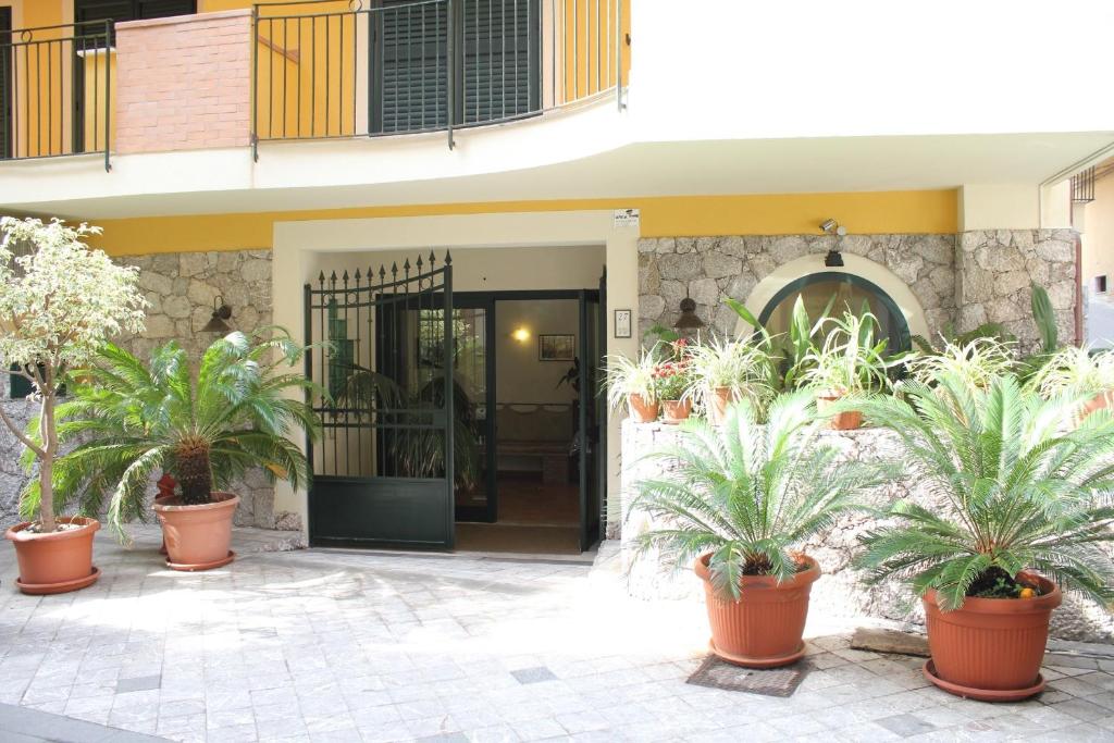 a house with potted plants in front of it at Le Tartarughe Aparthotel in Letojanni