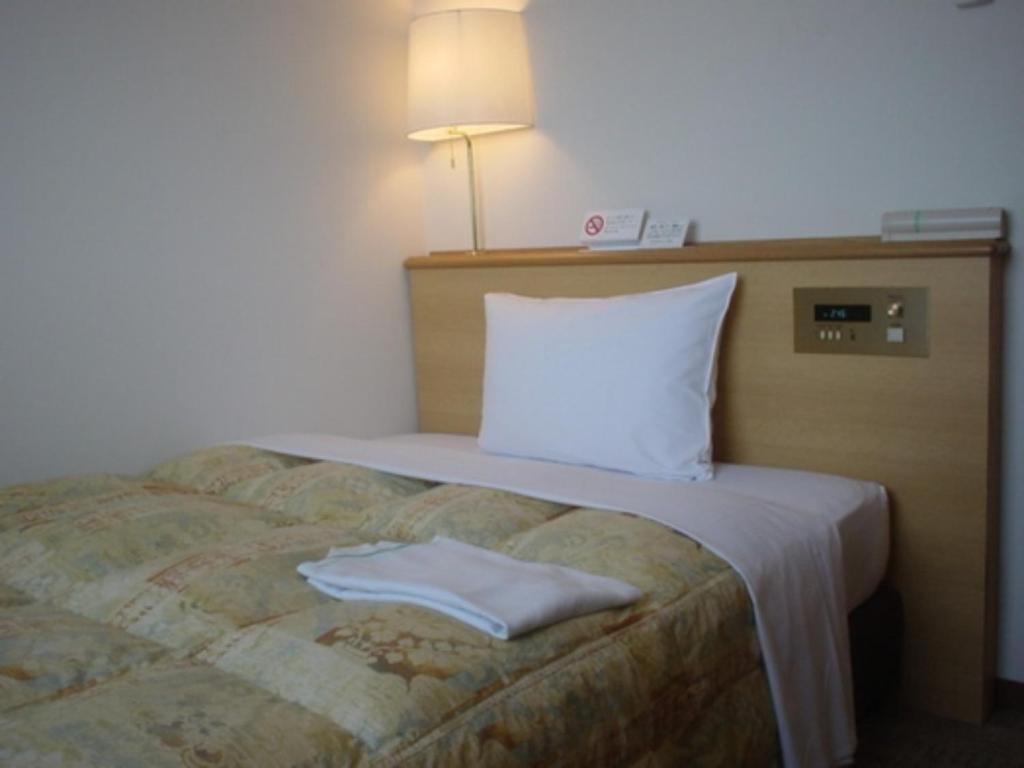 een hotelkamer met een bed met een witte handdoek erop bij Cosmo Inn - Vacation STAY 42013v in Fukuroi